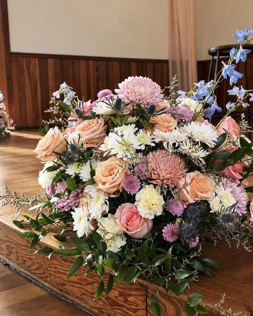 Full pastel arrangement of roses, dahlias and delphinium
