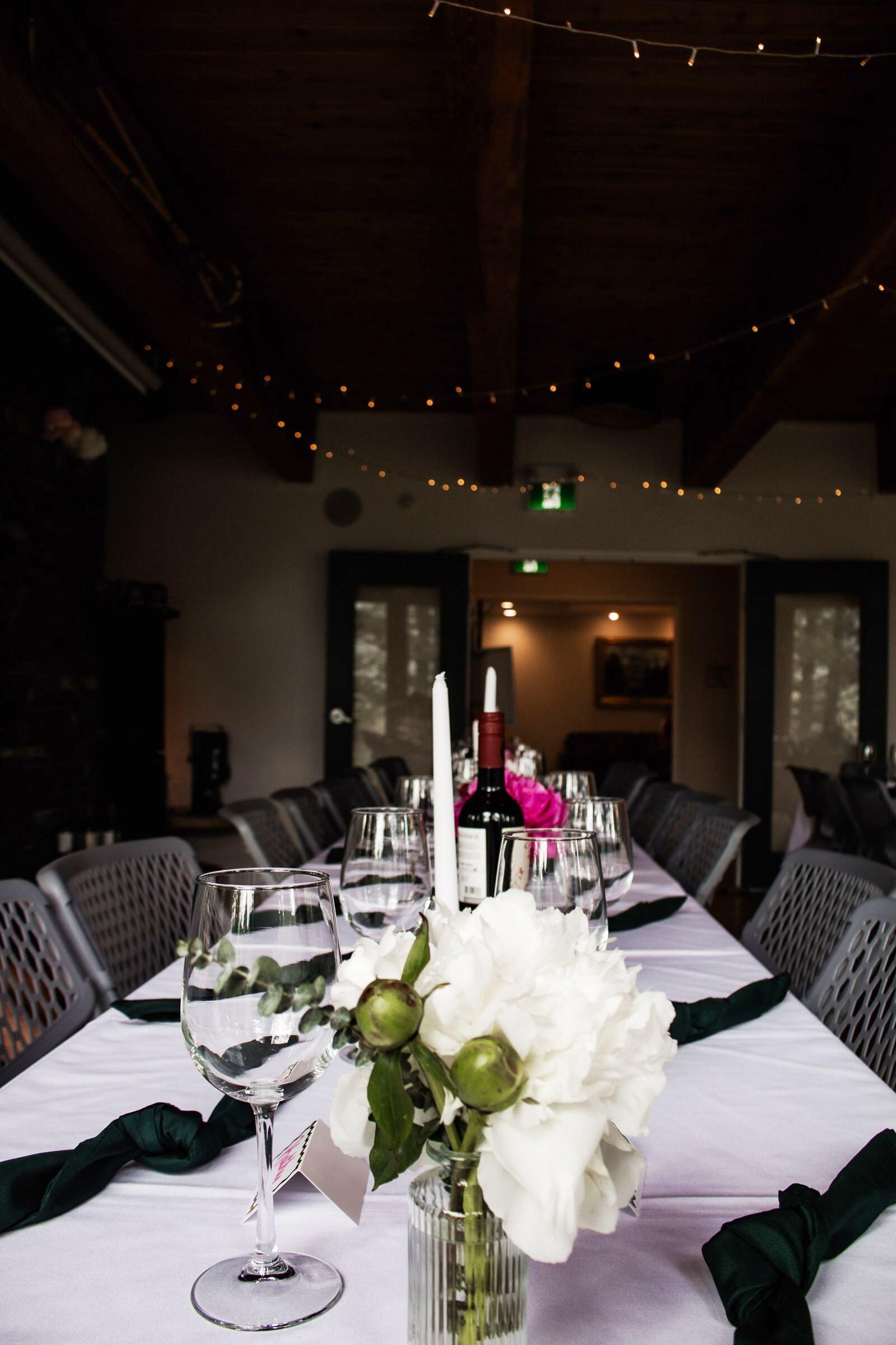 Long reception table with white garden roses and candles