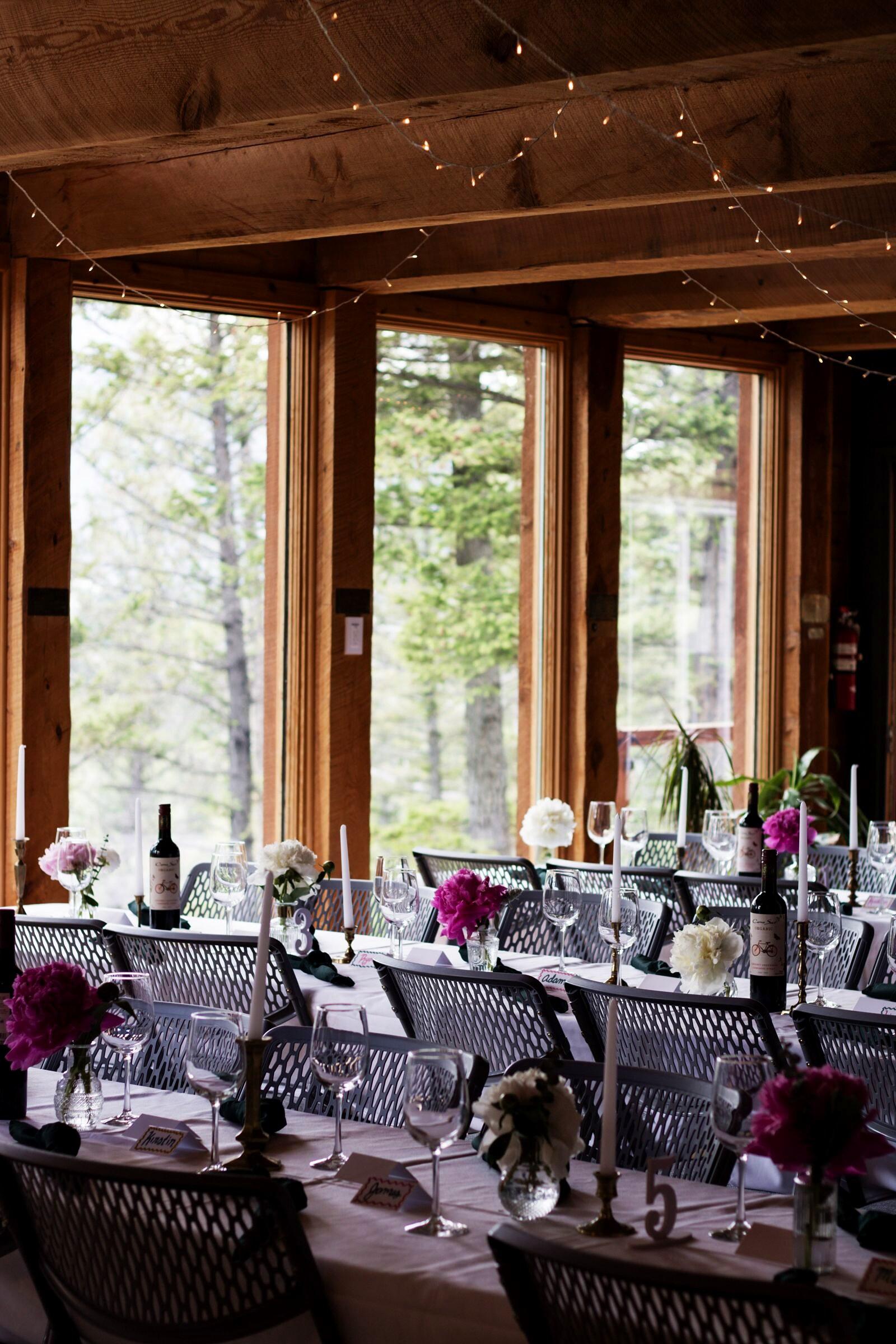 Reception tables with bud vases and mountain views through the windows