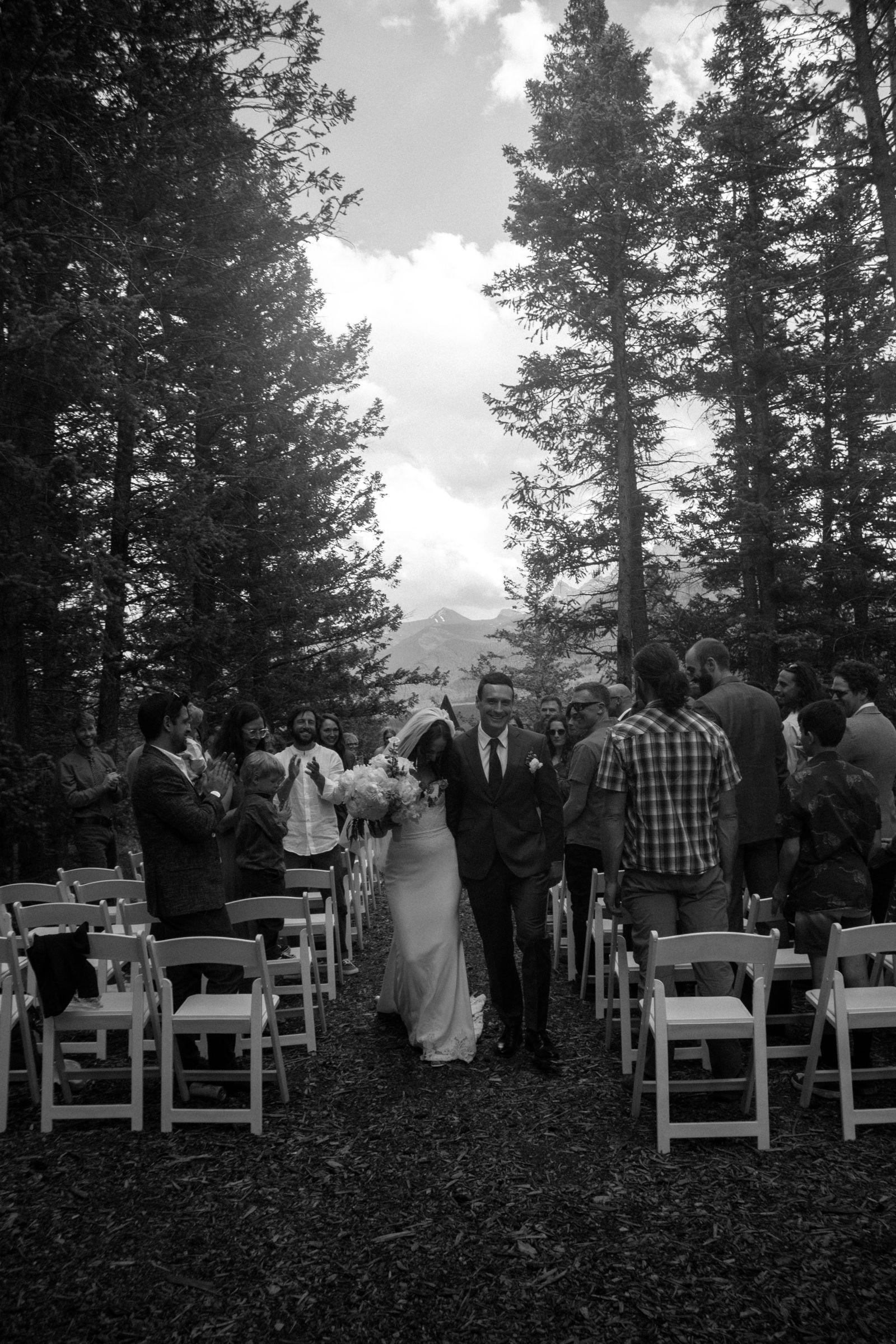 Black and white photo of the recessional through the forest aisle