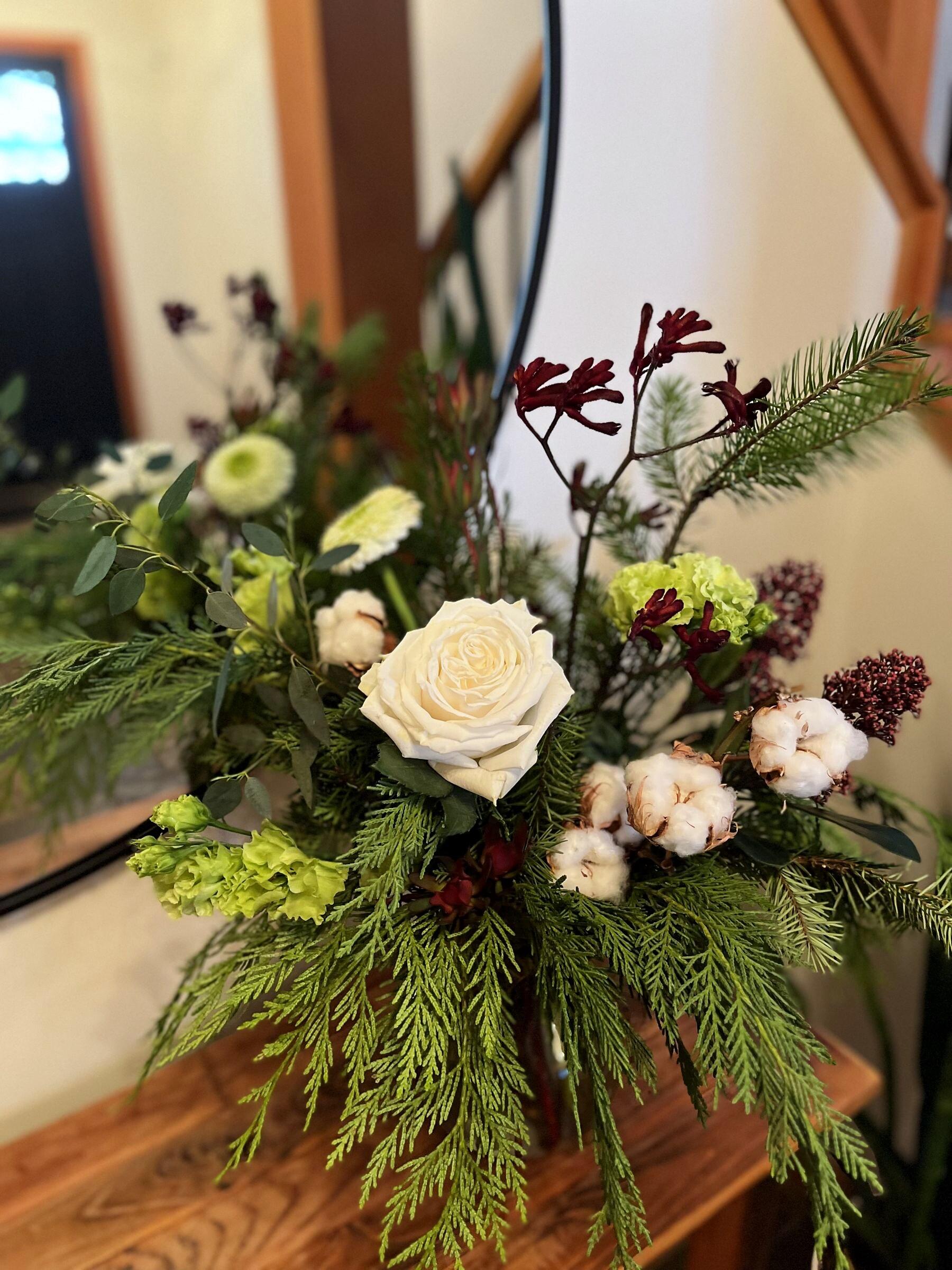 White rose and evergreen winter arrangement in the studio